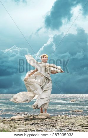 Woman In The Costume Of A Nymph Standing On The Beach In The Wind