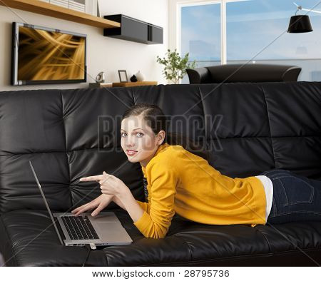 Meisje op Bank met Laptop, geeft ze aan het scherm met één vinger