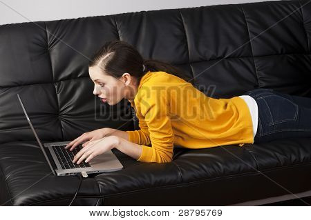 Meisje op Bank met Laptop, ze horloges het scherm met expressie van Surpraise