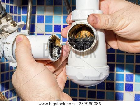 The Plumber Disassembles The Siphon Under The Sink To Clean It From Dirt.  House Master.