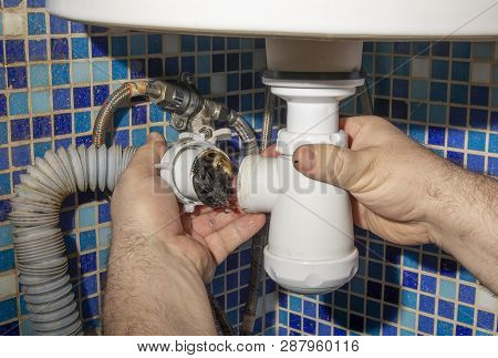 The Plumber Removes The Blockage In The Pipes, Disassembles The Siphon And Pulls Out The Dirt. Close