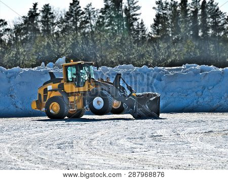 Front End Loader Takes Short Rest And Tilts Back On Two Wheels During Job To Snow That Has Been Clea