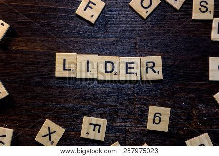 Lider Word Made With Scrabble Letters On A Black Wooden Table.