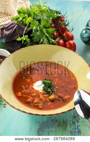 Red Beetroot Soup Borshch With Beef And Sour Cream On Blue Wooden Table