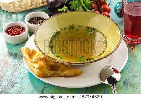 Low Fat Chicken Broth With Meatball In Bowl On Blue Wooden Table