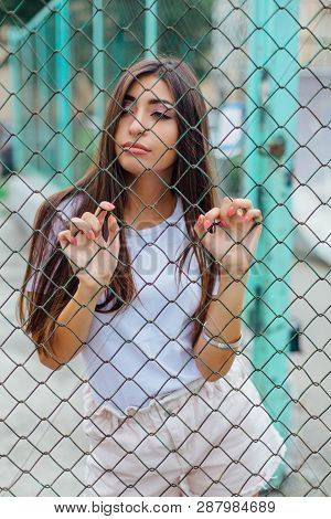 Portrait Of A Swag Girl Behind Rabitz Fence