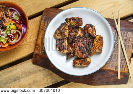Plates Of Pan-asian Salad With Sesame Seeds And Grilled Chicken In Pad Thai Sauce On Wooden Stands A