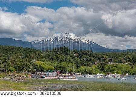 Pucon, Chile-january 31, 2020: Boats On The Shore Of Lake Villarrica With The Volcano Of The Same Na