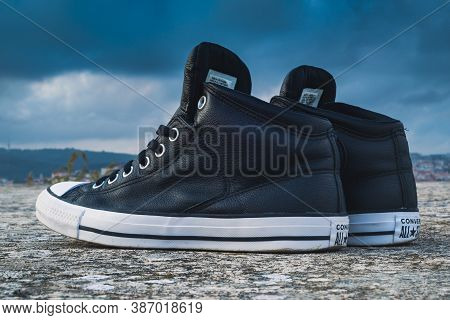 Close Up Photo Of Classic Style Black And White Leather Converse All Star Sneakers On The Concrete O
