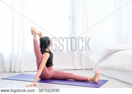 Young Woman Do Yoga In A Bed Room