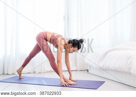Young Woman Do Yoga In A Bed Room