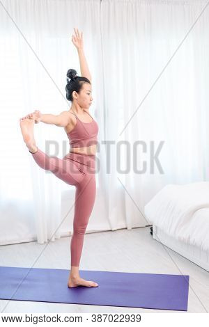 Young Woman Do Yoga In A Bed Room