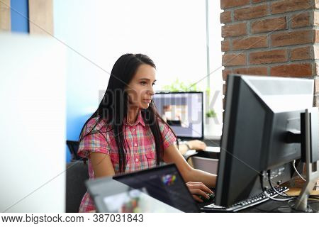 Woman In Office Sits At Computer And Looks At Monitor. Employee Training For Remote Work Concept