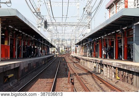 Fushimi-ku, Kyoto, Japan, November 17, 2017 : The Railroad Tracks With Passengers Waiting For The Tr