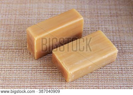 Two Pieces Of Brown Soap On The Table.