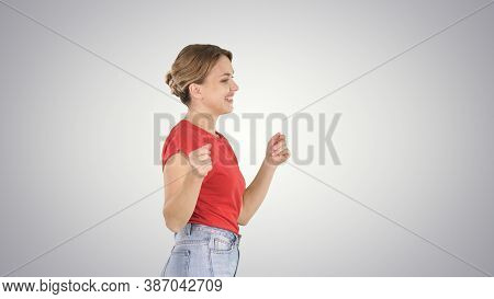 Young Woman In Red T-shirt, Jeans Dancing And Walking On Gradien