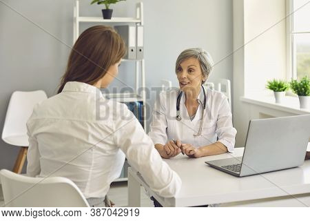 Senior Woman Doctor Therapist Consulting Young Woman Patient In Medical Clinic Office