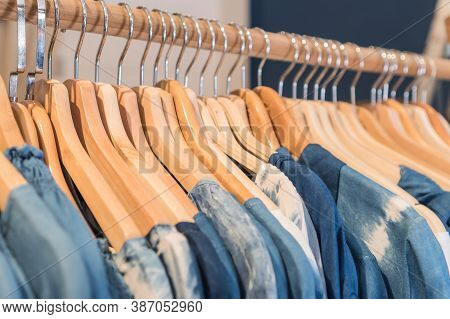 Ladies Clothes On Wooden Hangers In Shelf Fashion For Sale In Shopfront Store, Retail Background.