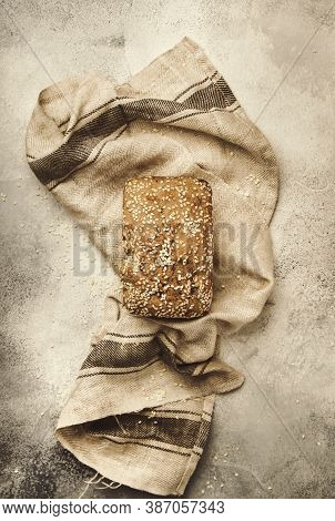 Whole Wheat Organic Rye Dark Bread With Pumpkin Seeds, Dried Fruit, Raisins And Sesame Seeds On Gray