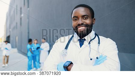 Portrait Of African American Young Doctor With Stethoscope Looking At Camera And Crossing Hands. Han