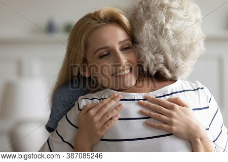 Loving Affectionate Millennial Daughter Holding In Arms Middle Aged Mother