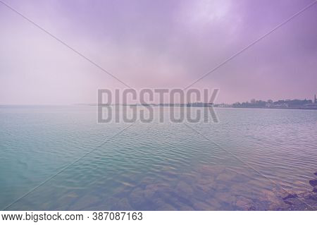 Deserted Shore Of Lake Garda In Italy In The Absence Of Tourism In Faded Color Effect.