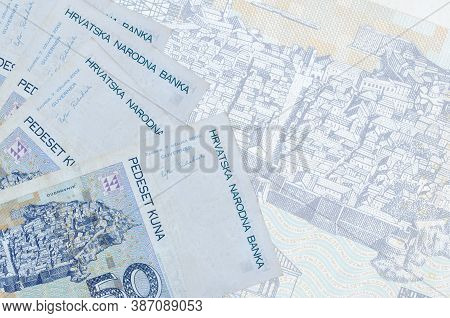 50 Croatian Kuna Bills Lies In Stack On Background Of Big Semi-transparent Banknote. Abstract Busine