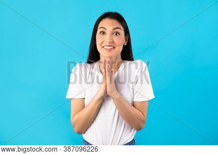 Desire Concept. Portrait Of Funny Lady Keeping Palms Together, Asking To Buy Her Something Or To Do 