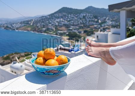 Woman Legs And Oranges On Terrace Bacony Of House Or Hotel Sea View