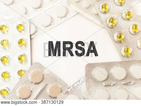 Text Mrsa On White Background. There Are Various Pills And Vitamins Around. Medical Concept
