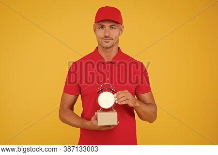On Time Delivery. Delivery Man Yellow Background. Courier Hold Clock And Box. Parcel Delivery Servic
