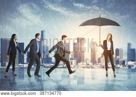 Businesspartners Hiding From The Rain Under An Umbrella On City Background. Business Protection Conc