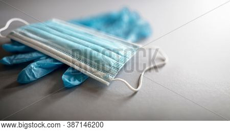 Medical face mask and latex gloves personal protective equipment background with copy space