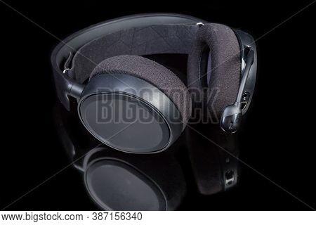 Black High-fidelity Headset With Earpads Circumaural Type And Microphone On A Dark Reflective Surfac