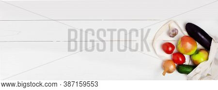 Various Vegetables And Fruits In An Eco-friendly Cloth Bag On A White Wooden Background, Top View. T