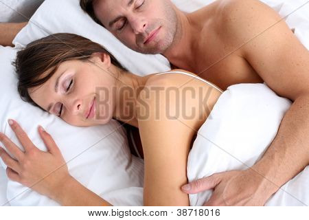 Vértes pár alszik az ágyban