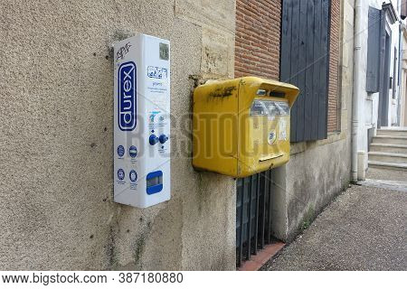 Bergerac, France: July 2020: Durex Vending Machine Next To A Post Box Mounted On The Wall Of A Build
