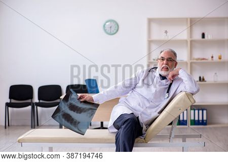 Old male doctor working in the clinic