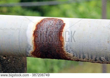 Antique Rust Water Pipes For Village Hydrant Water On Green Background. A Pipe For Conveying Water S