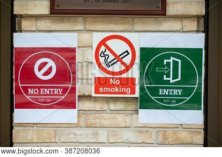 London - September 12, 2020: Covid 19 Social Distancing Warning Signs Alongside A No Smoking Sign On