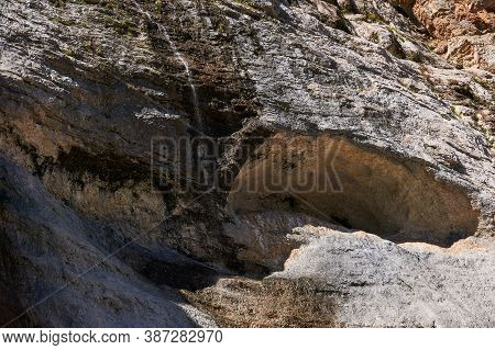 Mountain Landscape - Rock Wall With Streams Of Water Flowing Down It Over The Talus