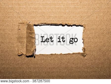 The Text Let It Go Behind Torn Brown Paper