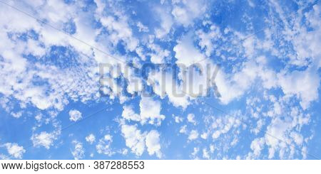 Beautiful Fluffy White Clouds In Blue Sky, Background. Altocumulus Cloud Formation