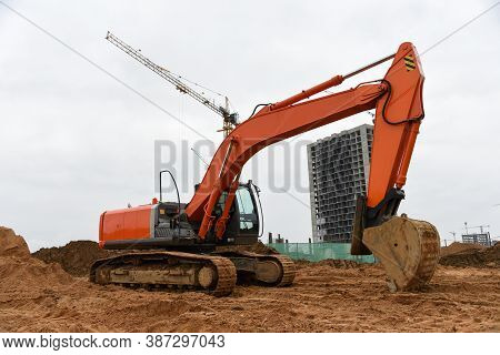Excavator During Excavation At Construction Site. Backhoe On Earthworks. Heavy Construction Equipmen