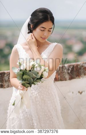 Beautiful Bride Stand In Frind Of City View With Bouquet And Smile