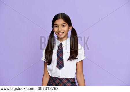 Smiling Smart Indian Hispanic Preteen Girl With Ponytails Wearing School Uniform Standing Isolated O