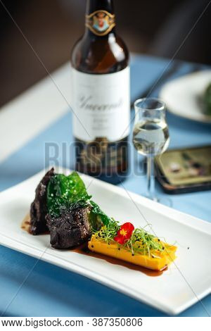Spanish Veal Cheeks In Wine Sauce And Sweet Potato Puree With Wine Bottle