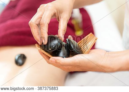 Close Up Spa Hot Stone Lying Down On Skin Back Woman.  Asian Beauty People Doing Massage Bed With Tr