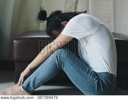 Blurred Young Barefoot Woman Sitting On The Floor With Her Head Down And Leaning Against, Sad Depres