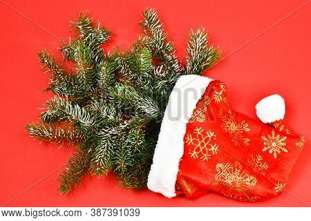 Creative Composition Christmas And New Year. The Christmas Tree Lies In The Cap Of Santa Claus On A 